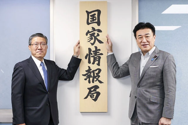 7月31日、「国家情報局」の看板を掲げる原和也国家情報局長（左）と木原稔官房長官（右）。同日、首相や関係閣僚が参加する国家情報会議の初会合も開かれた
