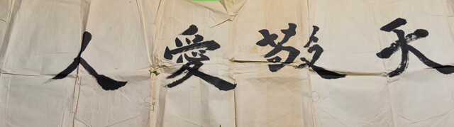 寺坂氏の母が工場を出すときに書いてくれた書。西郷隆盛の「天を敬い人を愛す」という言葉から取った。「天愛貿易」の名はここからきている