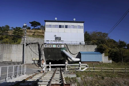 ２年前に、対馬より先に工事が進んでいた、佐賀県唐津市鎮西町の「日韓トンネル」。トンネルは小高い山の斜面にポッカリ開き、入り口近くには作業員宿舎が立ち、掘削した石などを地上に上げる無蓋車や掘削用の重機も置いてあった。トンネルを下って６、７分、５４０ ｍで切り羽（最深部）に到達。コンクリートで覆われることもなく岩盤はむき出しだ った。トンネルの傾斜があまりに急で、何かにもたれていないとキツいほどだが、この急な傾斜は対馬のトンネルでも同様だ