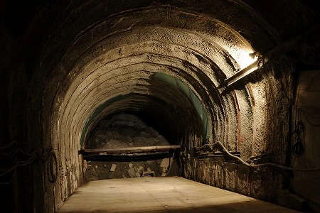 ２年前に、対馬より先に工事が進んでいた、佐賀 県唐津市鎮西町の「日韓トンネル」。トンネルは小高い山の斜面にポッカリ開き、入り口近くには作業員宿舎が立ち、掘削した石などを地上に上げる無蓋車や掘削用の重機も置いてあった。トンネルを下って６、７分、５４０ ｍで切り羽（最深部） に到達。コンクリートで覆われることもなく岩盤はむき出しだ った。トンネルの傾斜があまりに急で、何かにもたれていないとキツいほどだが、この急な傾斜は対馬のトンネルでも同様だ