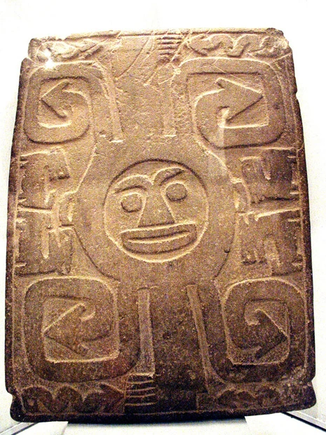 擬人化された太陽の顔を彫ったチリパ石板。渦巻き文様は簡略化され矢印に。その点がマルタ渦巻き石板とは違うが、四隅が巻いているのは共通。
