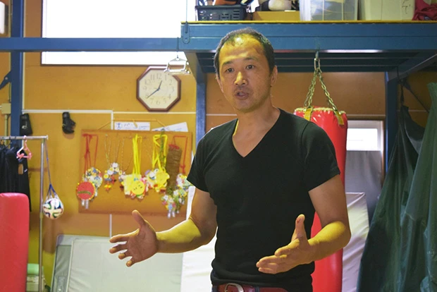 経営するスポーツジム F2 ZONE(エフツーゾン)にて語る、海老名さん。数々のヒーローを生み出した空間には、あちこちに造形物が並ぶほか、壁には、子供達からのお手製メッセージも飾られていた