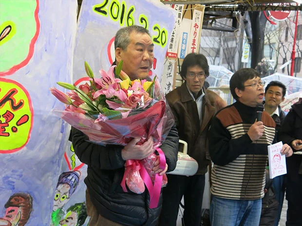 最後の営業日に花束を渡され涙ぐむ竹部さん