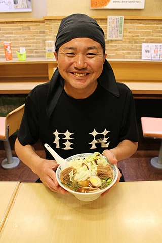 新宿ふぁんてん店店長の斉藤竜平さんと「7割ぐらいのお客さんが頼む」という『太肉麺』(980円)