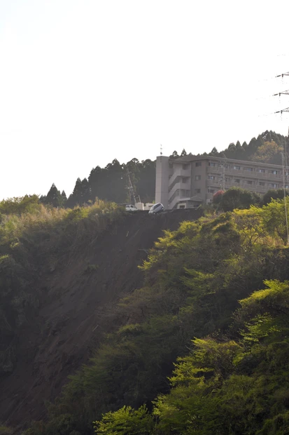 南阿蘇村にあるコンビニの駐車場にとめてあった軽自動車が今にも落下しそうになっている