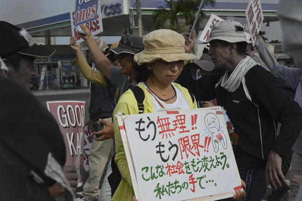 プラカードを自作し、出勤前に嘉手納基地前に女性。そこには「もう無理！！　もう限界！！」との怒りの文字が…