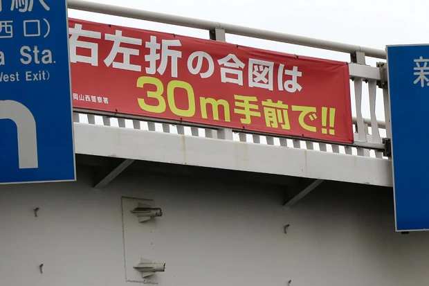  岡山市内では、交差点や歩道橋など至る所にウインカーを出すよう指示する横断幕が。県外者にとってはちょっと違和感？