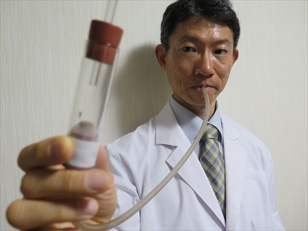 学生時代から25年間、蚊の研究を続ける白井良和氏。手に持つのは蚊の捕獲器