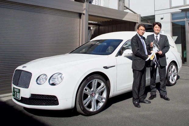 納車を記念して、熊木社長（右）に大きな鍵を渡す河村社長（左）は「今は世界的な霊柩車ブームで海外からの需要も多い」と語る