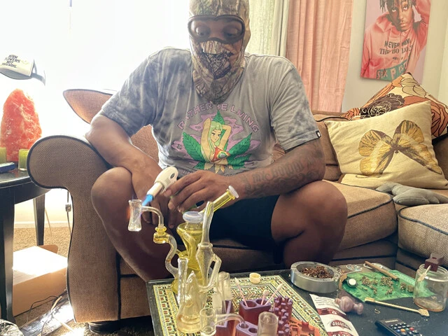 闇大麻を扱うウィンさん。顔出しNG。机の上には特殊な喫煙具がズラリ