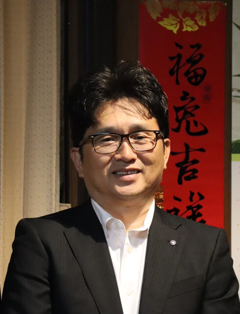 取材に応じてくれた菊陽町の吉本孝寿町長。背後の書は、友好提携を進める台湾の宝山郷から贈られた。宝山郷にもTSMC工場があるためのつながりだ