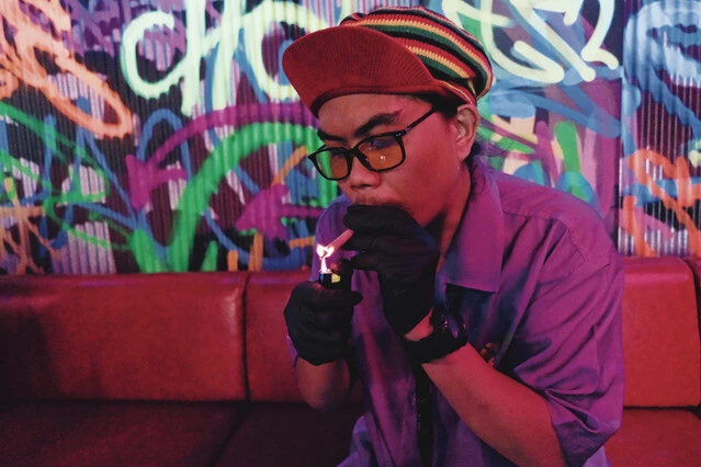 カオサン通りにあるバーの店員。乾燥大麻の葉を専用のフィルターで巻いて吸う