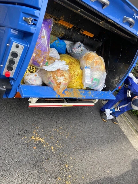 破裂したゴミ袋から飛び散るカレー。靴についたカレーを拭いています