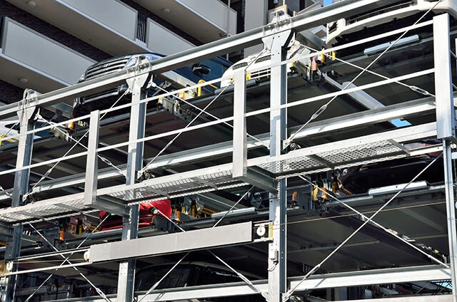 屋外の鉄骨製機械式駐車場は特にクルマの温度が高くなるといわれており、車内の電子機器だけでなくEVのバッテリーの状態にも注意が必要だ（写真はイメージ）