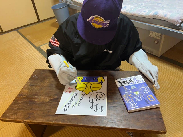 単行本の刊行にあたりサイン色紙を描く宮野さん。単行本は現在発売中
