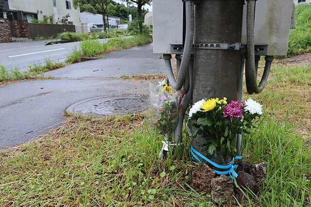花が供えられている兵庫・丹波篠山市の遺棄現場。中央左に見えるマンホールを下水道業者が開けたところ、赤ちゃんの遺体を見つけた(撮影/安田峰俊)
