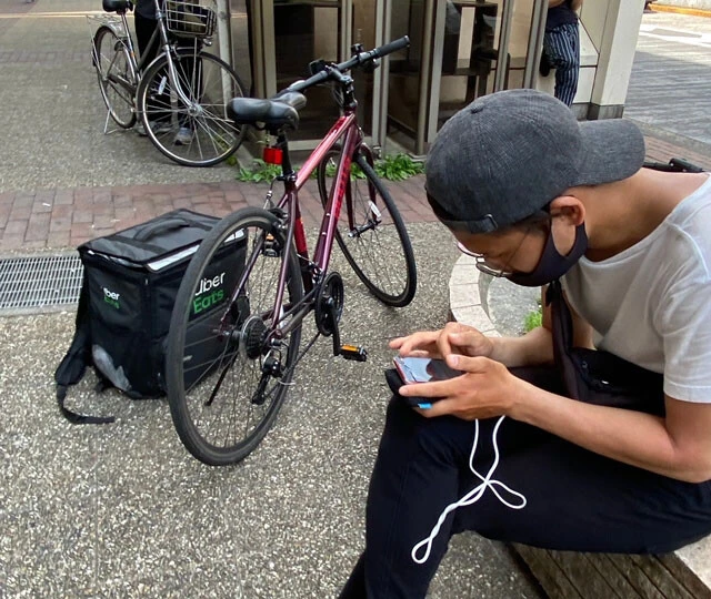 地蔵（路上での配達リクエスト待ち）をするフードデリバリー配達員。当然、待機時間は一銭にもならない
