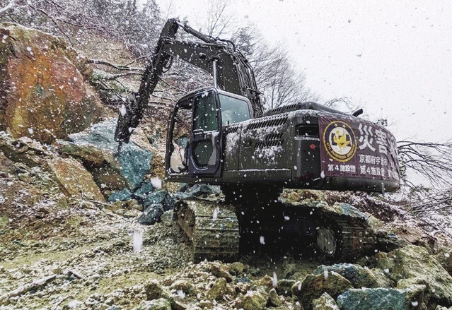 油圧ショベル　分断された道路の復旧活動を行なう第102施設器材隊。「実は陸上自衛隊の装備する油圧ショベルは、本体をオリーブドラブ色に塗っただけで性能は民生品と同じです」（照井氏）