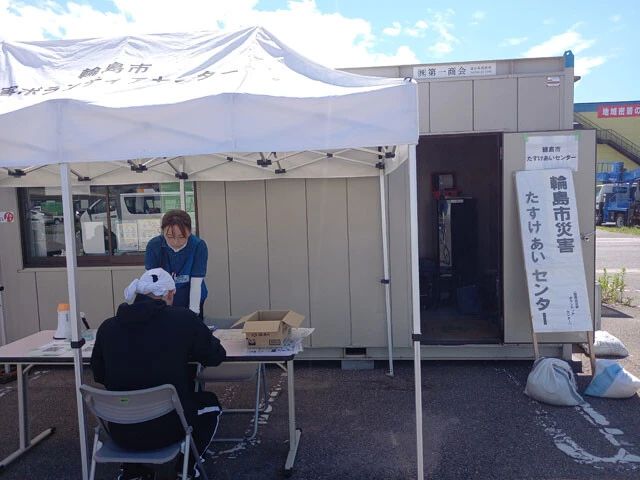 輪島市の災害ボランティアセンター。金沢市内からシャトルバスで人員を迎え入れる。取材日の登録者は39人。群馬県の社会福祉協議会から応援に来ていた望月麻理恵さんによると「今は荷物の運搬や瓦礫の撤去、コンクリートと鉄芯を分ける作業などが多いです」。水害を受け現在は一時活動休止に