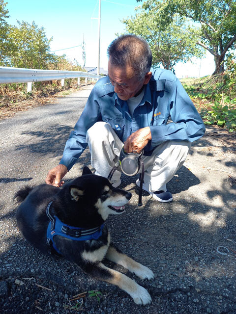 中竜夫さんとクロちゃん。中さんの妻・紀子さんは地震後、孤立した集落での避難生活の心労で亡くなった。「クロの面倒は6年間ずっとカカアが見てた。ようやく慣れてきたところです」と抜け毛を取る