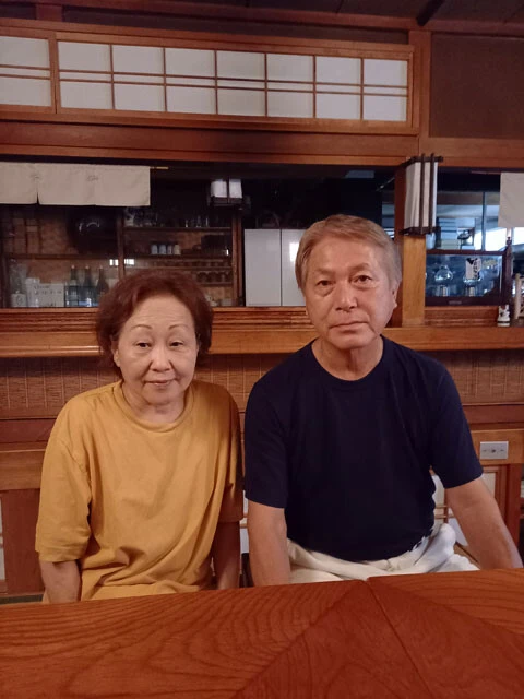 中竜夫さんとクロちゃん。中さんの妻・紀子さんは地震後、孤立した集落での避難生活の心労で亡くなった。「クロの面倒は6年間ずっとカカアが見てた。ようやく慣れてきたところです」と抜け毛を取る