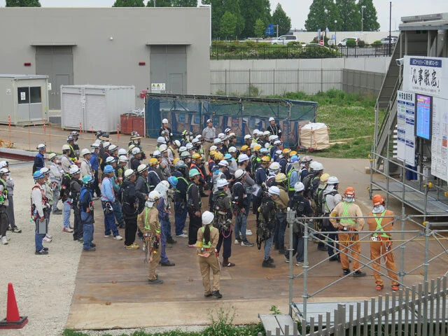 印西牧の原駅前の商業モール敷地内で、2棟目となる大型DCの建設が進む。平日の朝、現場では作業員たちが作業内容を確認する朝礼に臨んでいた