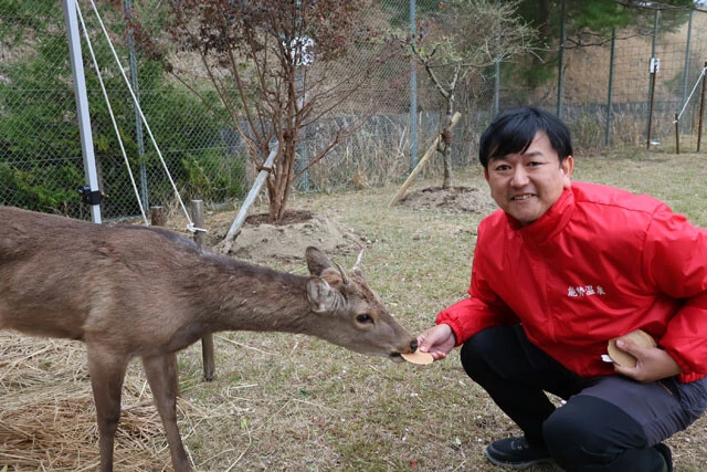 シカやんと、保護した「能勢温泉」の西山竜也社長。鹿せんべいが大好き?