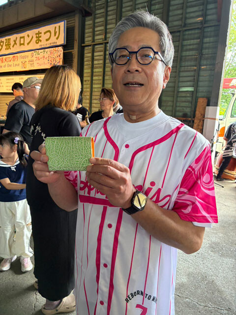 夕張メロンまつりを訪れた厚谷市長。前市長から受け継いだ「夕張メロン柄」の名刺入れで町をアピールしていた