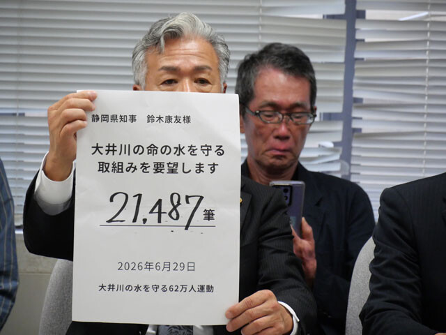 6月29日、2万1487人分の署名を県職員に手渡した後、記者会見で署名数を掲示する62万人運動のメンバー