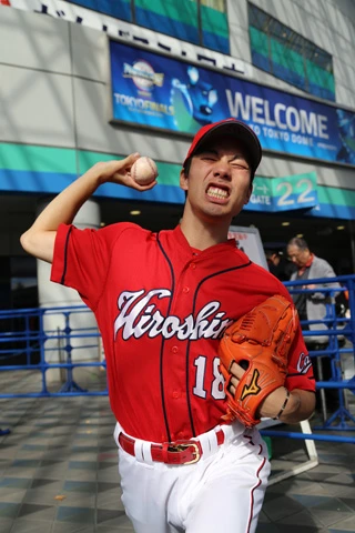 踏ん張るような表情で投げるマエケンのフォームをまねるマネケン氏