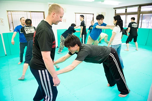 ペアの身体を使っての拳立て。相手の筋肉の上に拳を置いて手首で支えるのだが、ぐらぐらしない場所(部位)を見つけるのが難しい