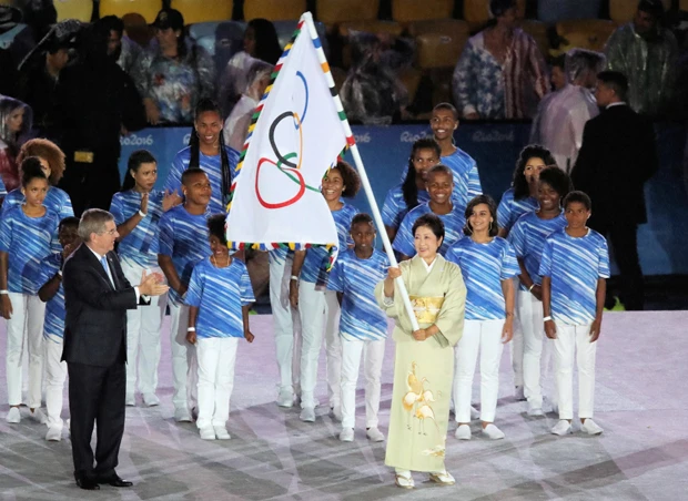 五輪旗を受け取る小池都知事 (写真/日本雑誌協会)