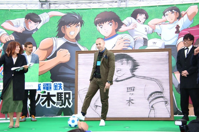 １１万枚の切符アートの前で、ボールを蹴るイニエスタ