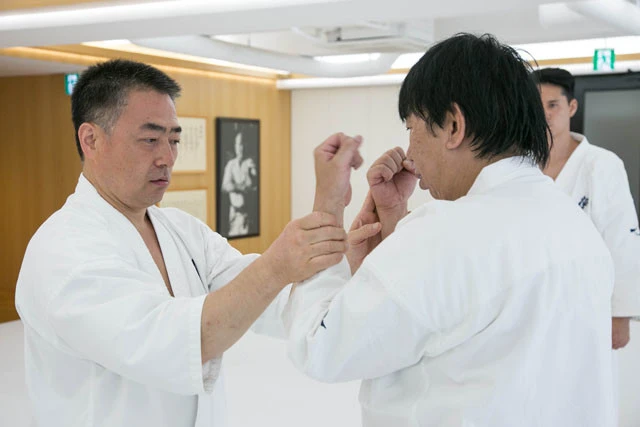 身振り手振りどころか、文字通り、手を取り足を取りでドラゴン先生を指導してくださる松井館長。壁の大山総裁の額装写真が稽古を見つめるなか、ひとつひとつの動きを確実に自分のものにしていく