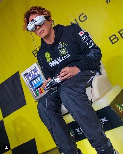 ゴーグルをつけドローンのカメラから送られてくる映像をもとに操る後藤氏