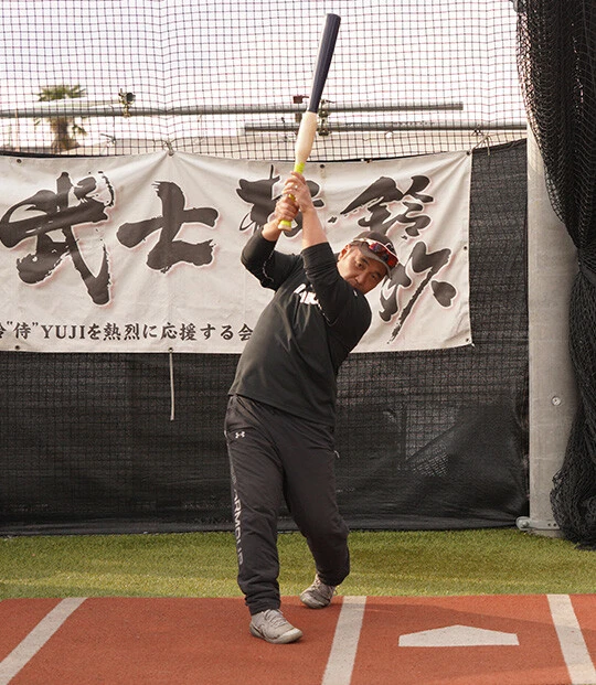 【鬼ダウンスイング】トップからヘッドを落としてスイングするため、投手側から見るとバットが縦に出てくるように見える。手首を返さずにバットの「面」をボールの軌道に長く入れるようにし、フォロースルーは自分の背中を叩くような軌道になる