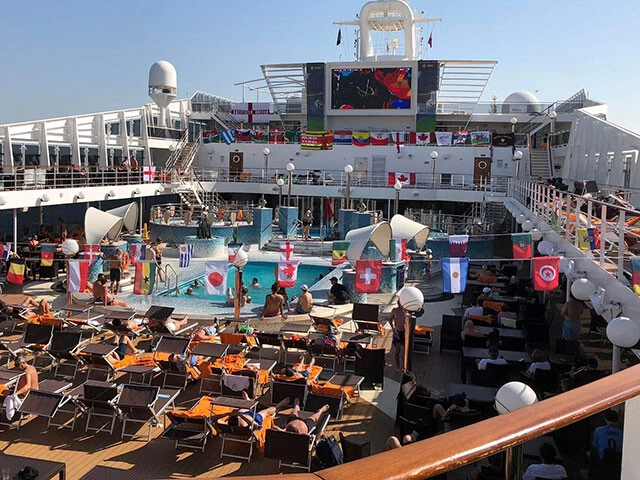 プールサイドに設置された大画面で試合を楽しむ人も