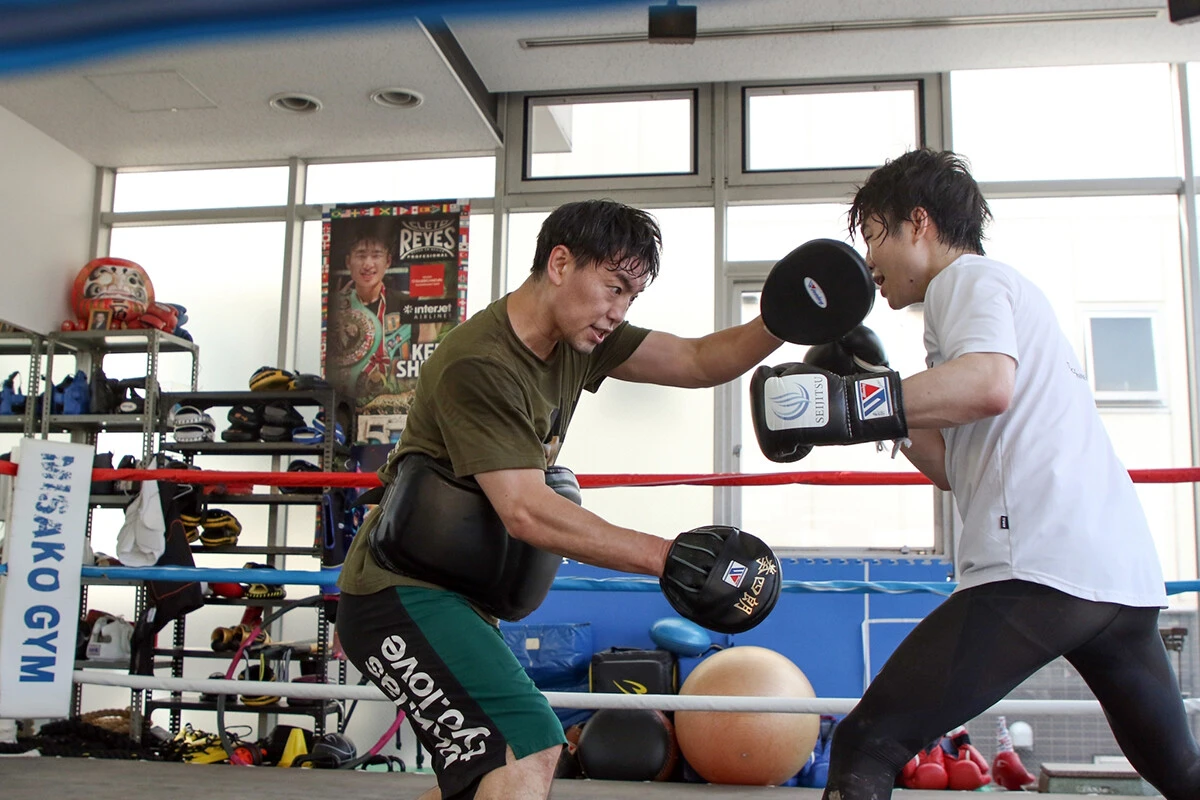 拳四朗が所属するのは地元・京都で父親が運営するB.M.Bジムだが、東京の三迫ジムに長期出稽古を続けている。チーフトレーナーの加藤健太（左）の指導を受けるためだ