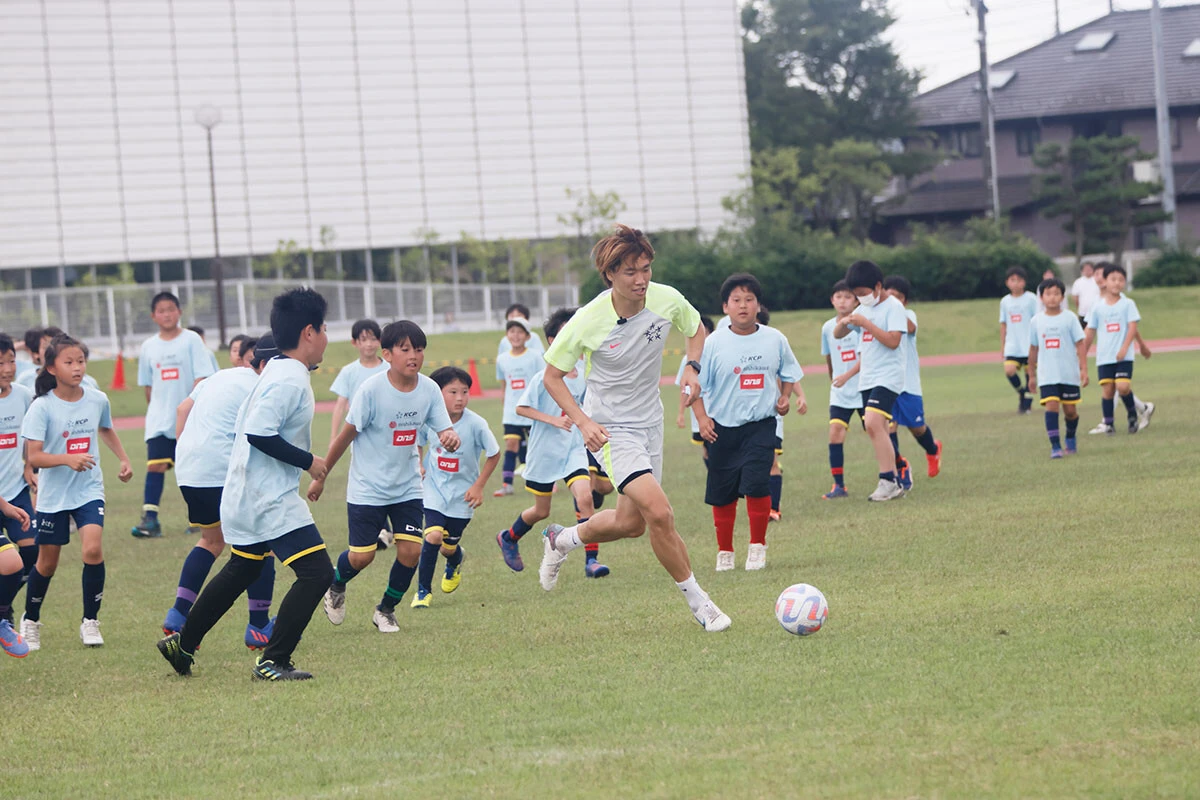 子ども100人チームからボールをキープする板倉選手