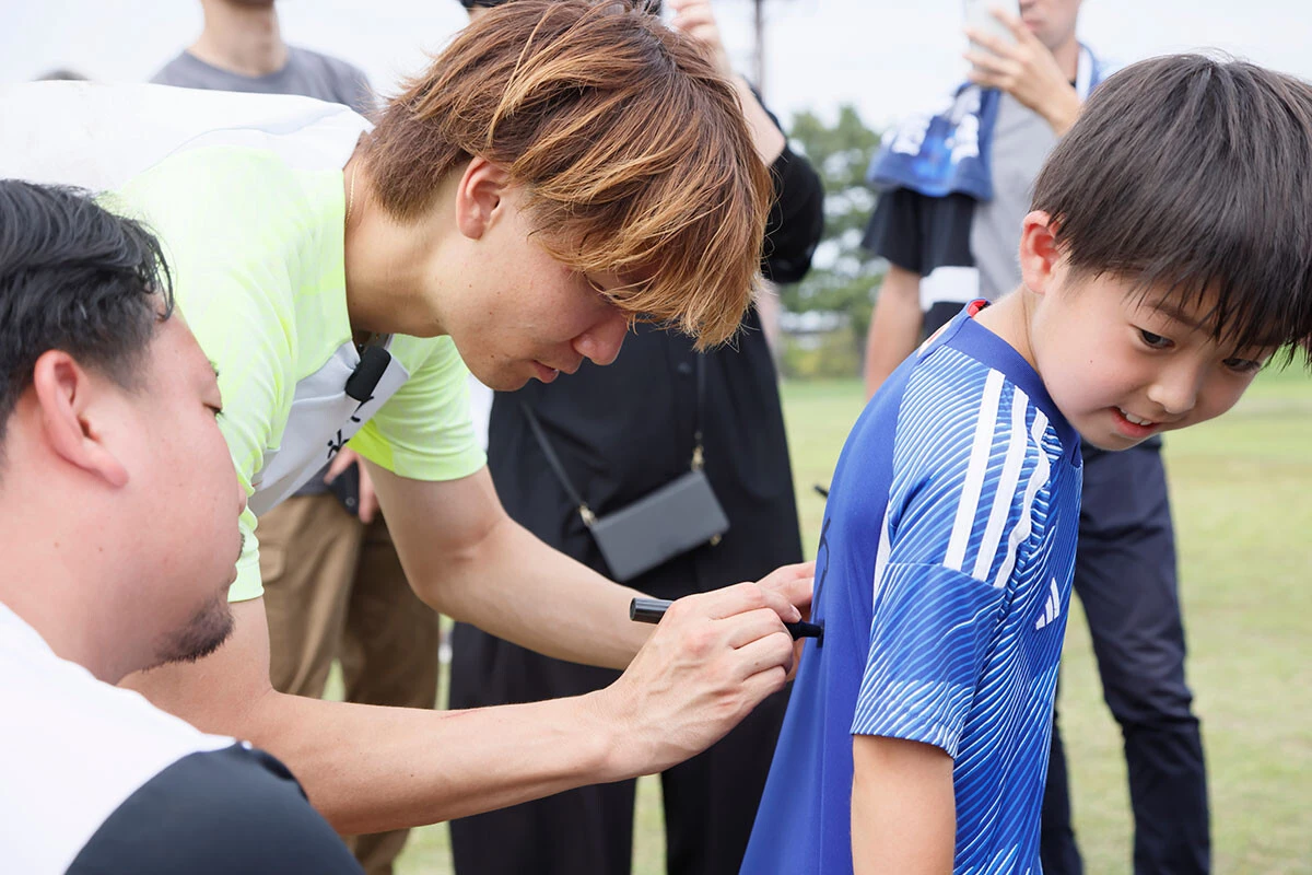 子どものユニフォームへサインする板倉選手