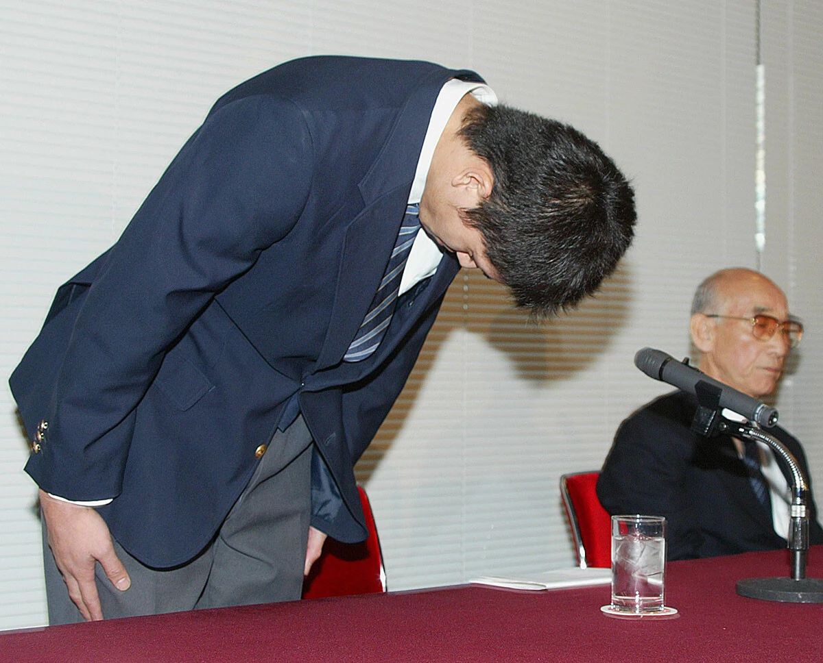 プロ球団からの金銭授受問題についての記者会見冒頭で、深く頭を下げる明治大学4年の一場靖弘投手（写真：時事）