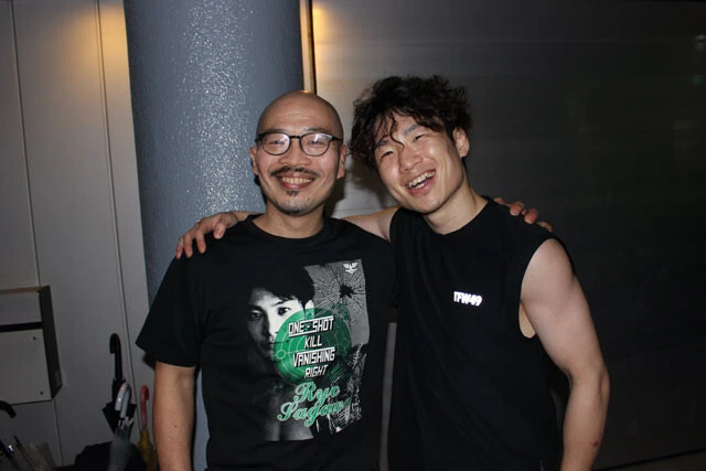 帰り際、ジムの前で記念撮影する拳四朗と横井トレーナー。チームに欠かせない明るいムードメーカだが、時に激しく気合注入する。