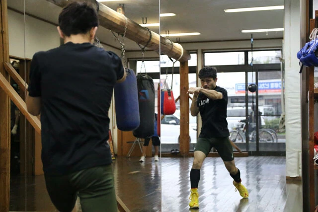 鏡に映る自分と会話をするようにシャドーを繰り返すユーリ阿久井。周囲は張り詰めた空気が漂っていた