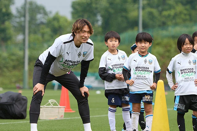 小学生にコーチングする板倉