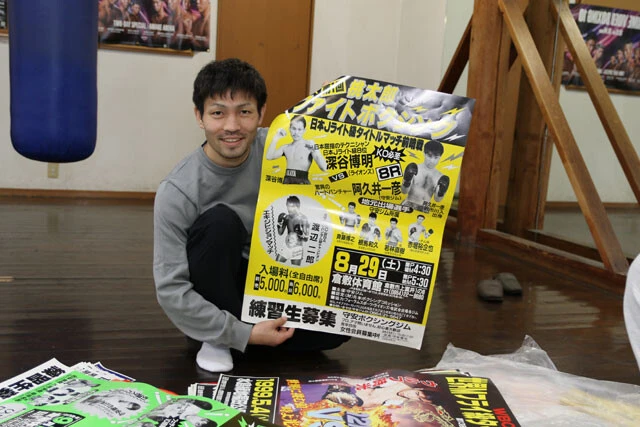 父・一彦が倉敷守安ジム初の自主興行に出た際のポスターを持つ阿久井。一彦は30戦13勝（3KO）15敗2分という成績を残し、37歳で引退した（撮影／会津泰成）