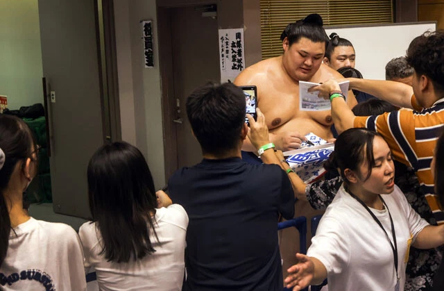 連日満員御礼の東北巡業で、通路に押し寄せるファンひとりひとりにサインをする大の里。横綱の人気ぶりに、場内整理の人も大変そう