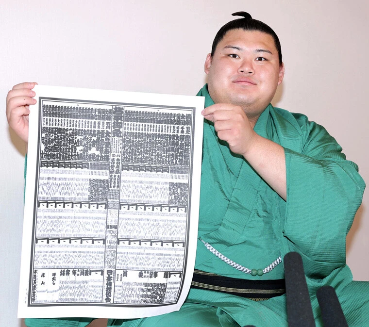横綱として名前が載った名古屋場所の番付表を手にする大の里。名古屋場所では横綱での初優勝で、3場所連続優勝なるか