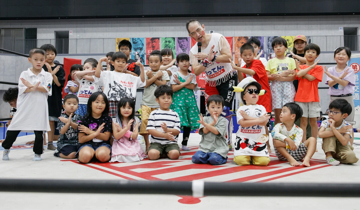リングを体験して笑顔の子供たちとばってん×ぶらぶら選手（中央）。未来のチャンピオンがここから生まれるかも？