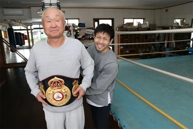 「家族のような存在」と話す守安会長の腰に世界チャンピオンのベルトを巻くユーリ阿久井