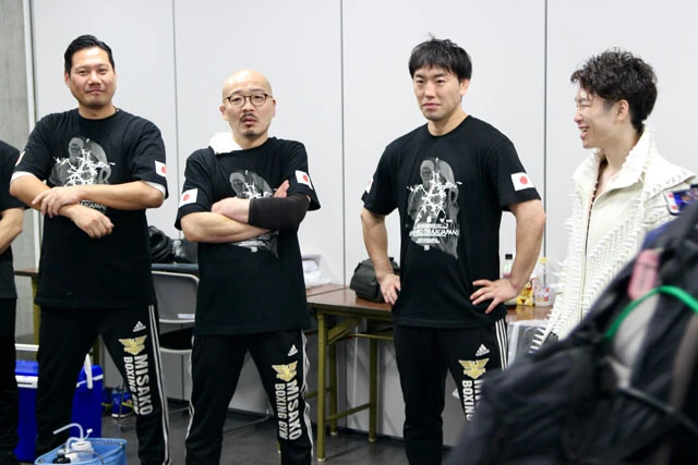 試合控室でセコンド陣（左から丸山、横井、加藤トレーナー）とリラックスして談笑する拳四朗。戦術面だけでなく、安心感を与えてくれる存在だ